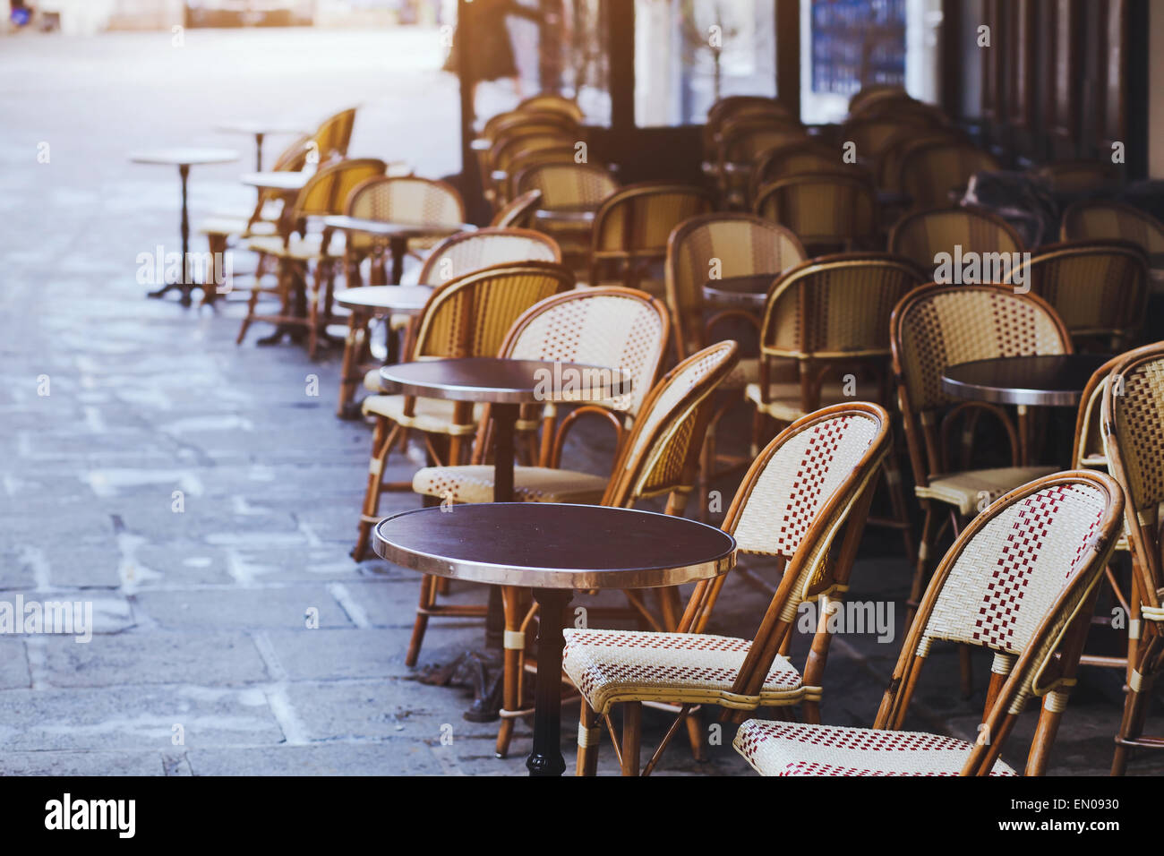 Café traditionnel à Paris avec terrasse ouverte, des tables rondes et des chaises en osier, France Banque D'Images
