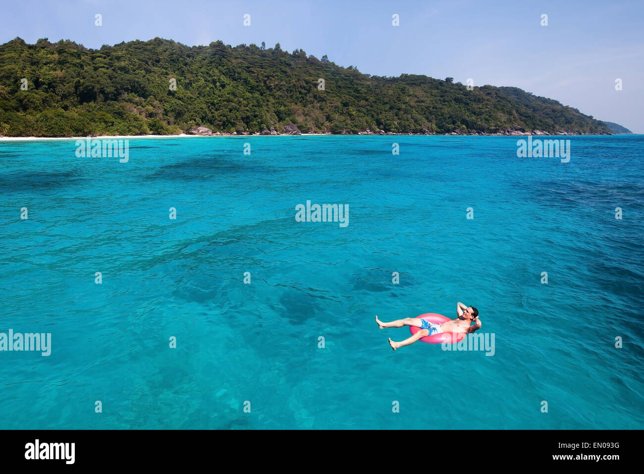 Billet d'avion concept, l'homme nage en bouée sur Paradise beach Banque D'Images