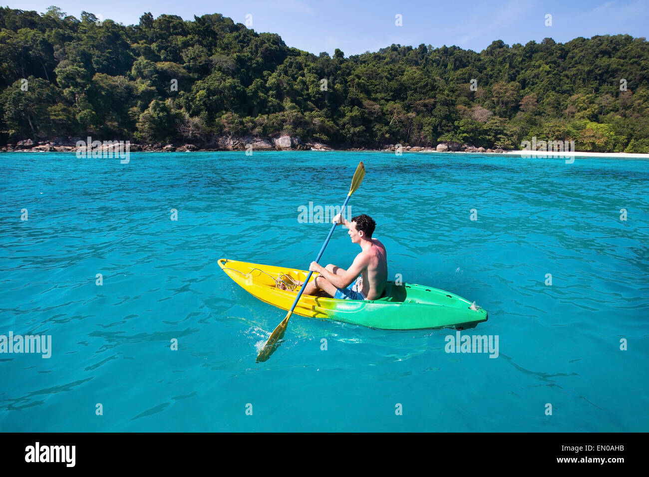 Young caucasian man en kayak près de Paradise Island dans l'eau turquoise Banque D'Images