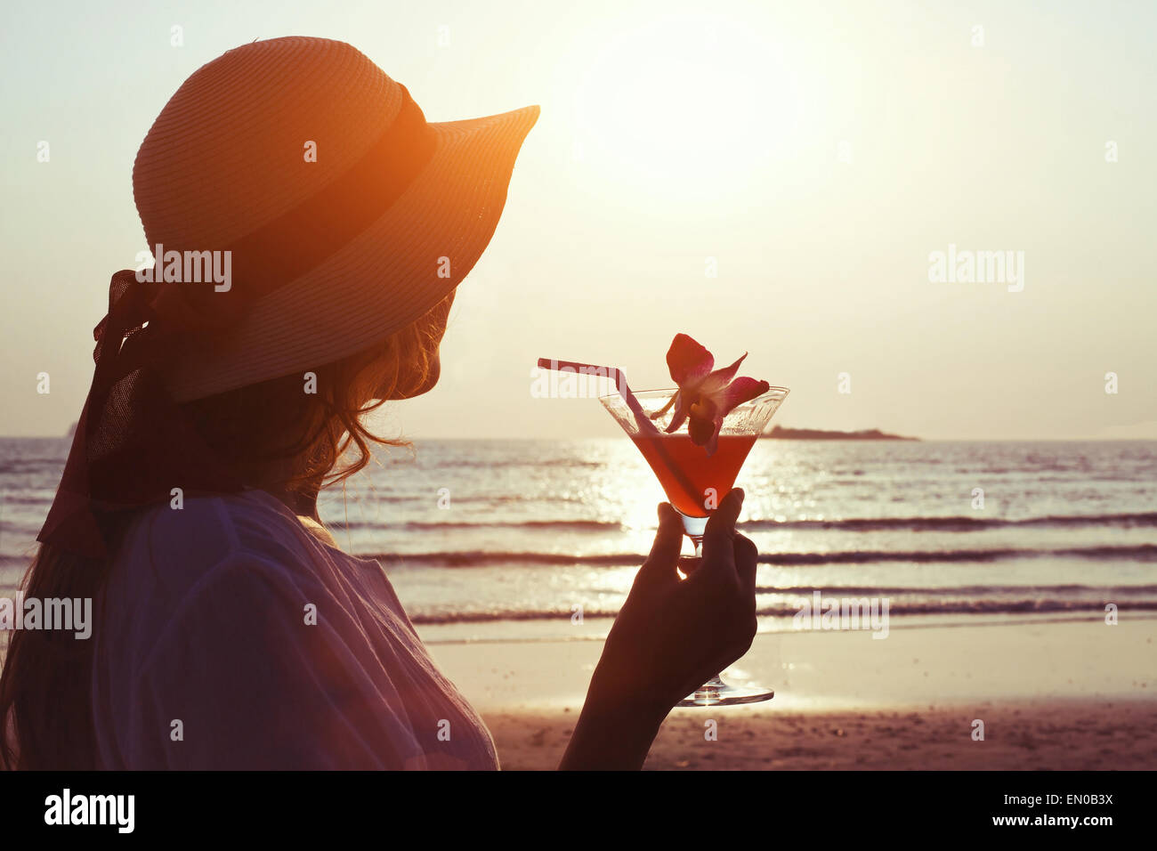 Femme avec cocktail au coucher du soleil plage Banque D'Images Femme avec cocktail au coucher du soleil plage Banque D'Images