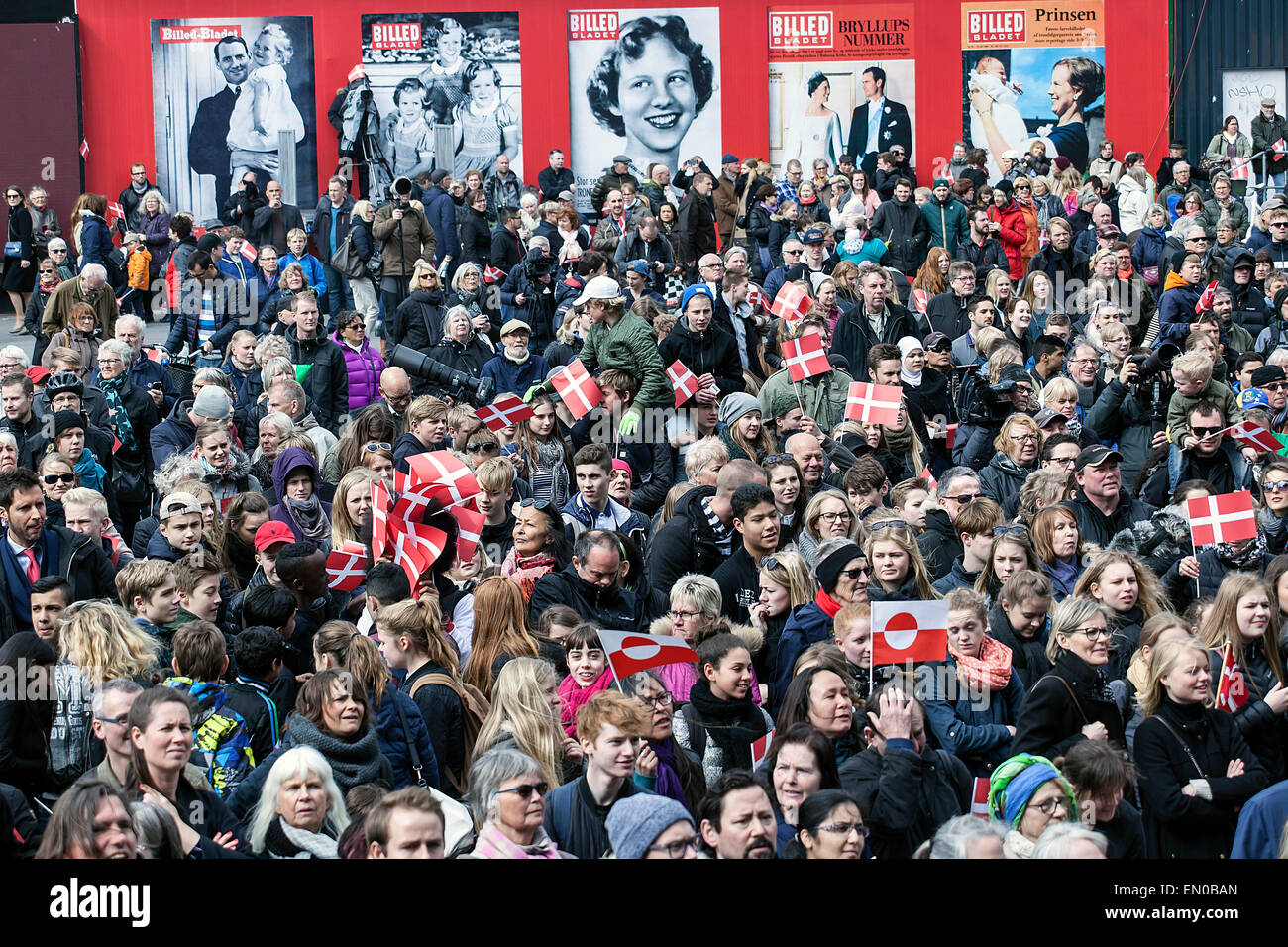 Copenhague, Danemark, avril16th, 2015. Les spectateurs de la place de l'Hôtel de ville de Copenhague en attente de la Reine Margrethe de comparaître à l'Hôtel de Ville balcon à l'occasion de son soixante-cinquième anniversaire. Bacgground : page d'affiches montrant des images de la Reine Margrethe à partir d'un petit enfant à maintenant Banque D'Images