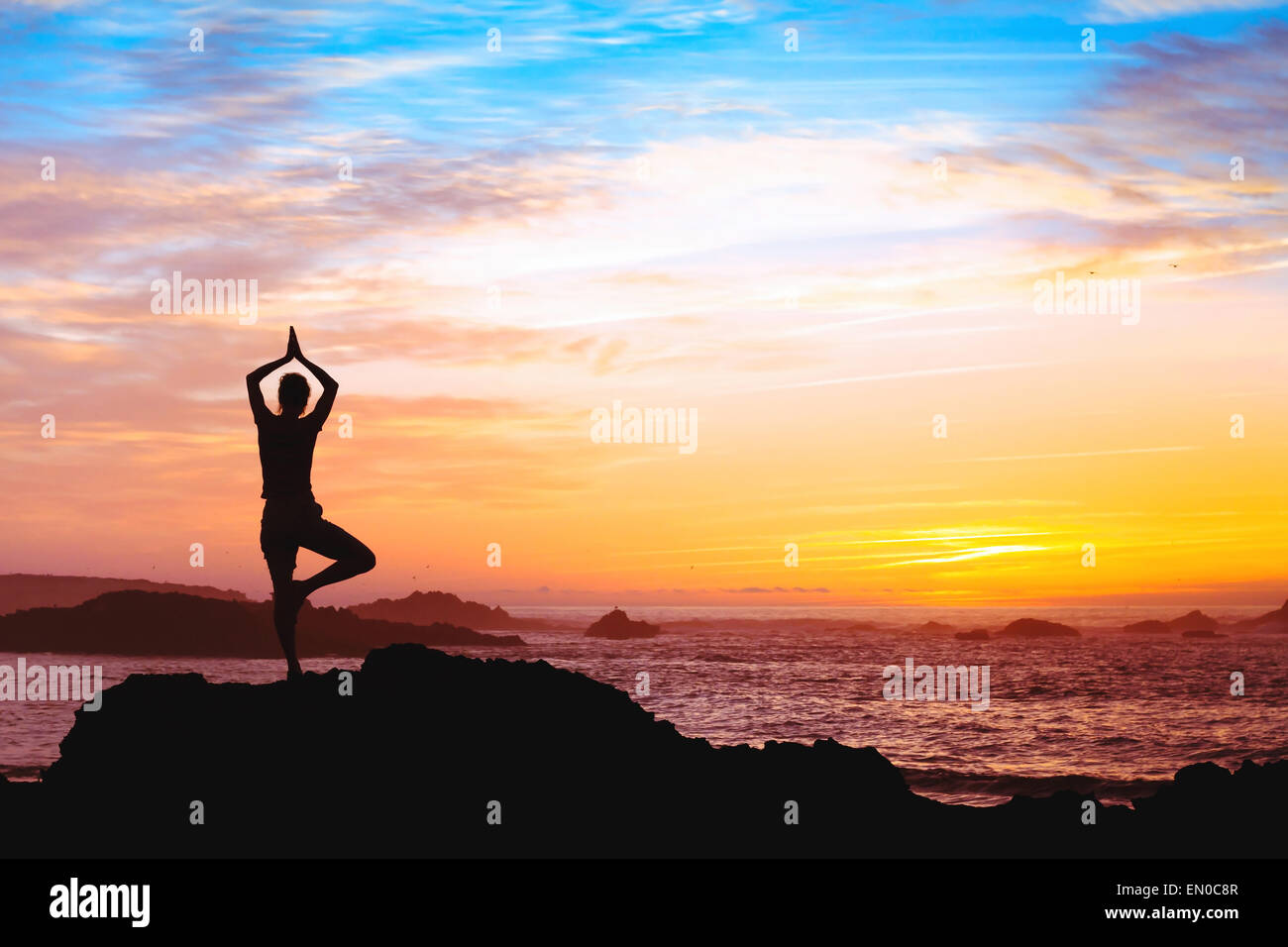 Belle silhouette of woman practicing yoga près de la mer Banque D'Images Belle silhouette of woman practicing yoga près de la mer Banque D'Images