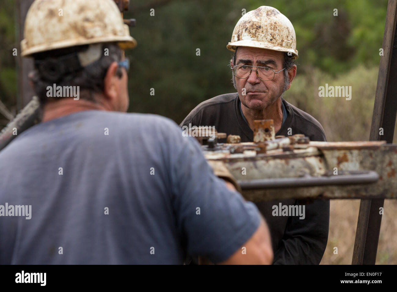 Les travailleurs du pétrole couler à l'aide d'un derrick de forage pour le pétrole brut dans Evangeline, Louisiane. Les champs de pétrole ont été les premiers puits en Louisiane. Banque D'Images