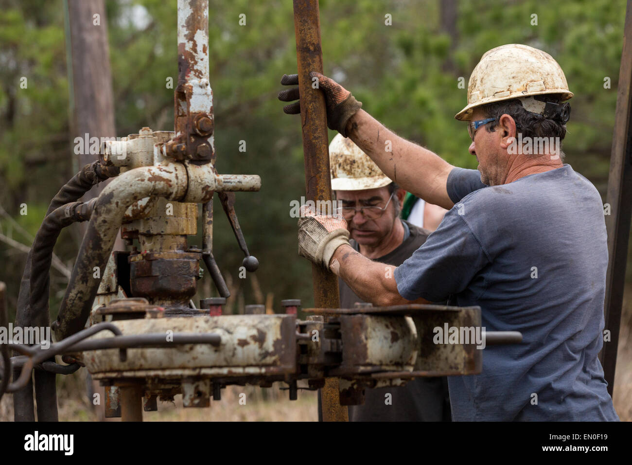 Les travailleurs du pétrole couler à l'aide d'un derrick de forage pour le pétrole brut dans Evangeline, Louisiane. Les champs de pétrole ont été les premiers puits en Louisiane. Banque D'Images