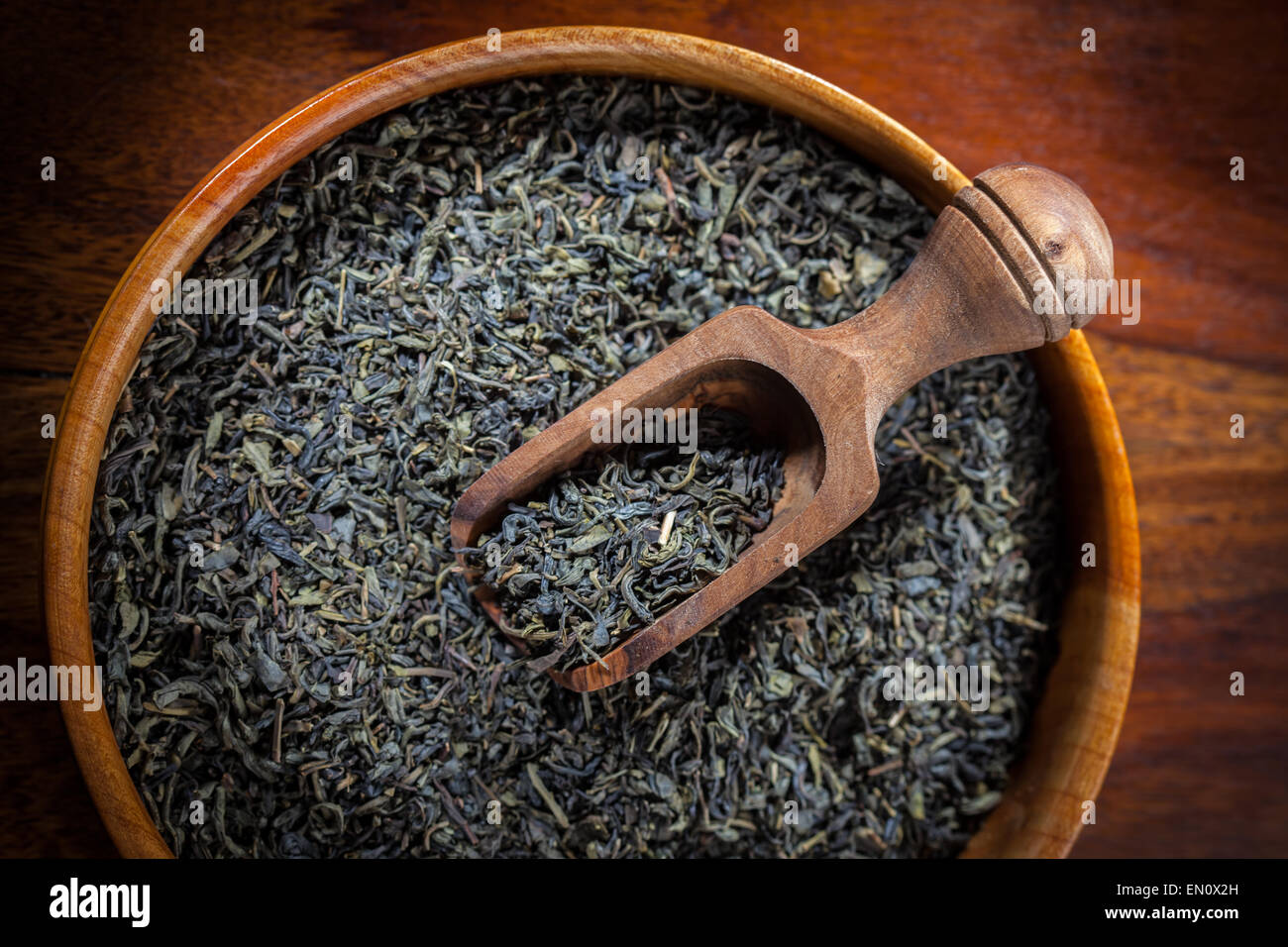 Thé vert à sec dans un bol en bois Banque D'Images