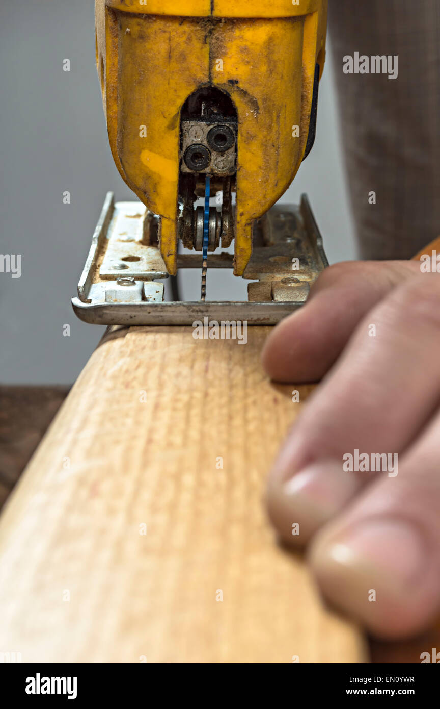 Menuisier couper un morceau de bois à l'aide d'une scie sauteuse Électrique Banque D'Images