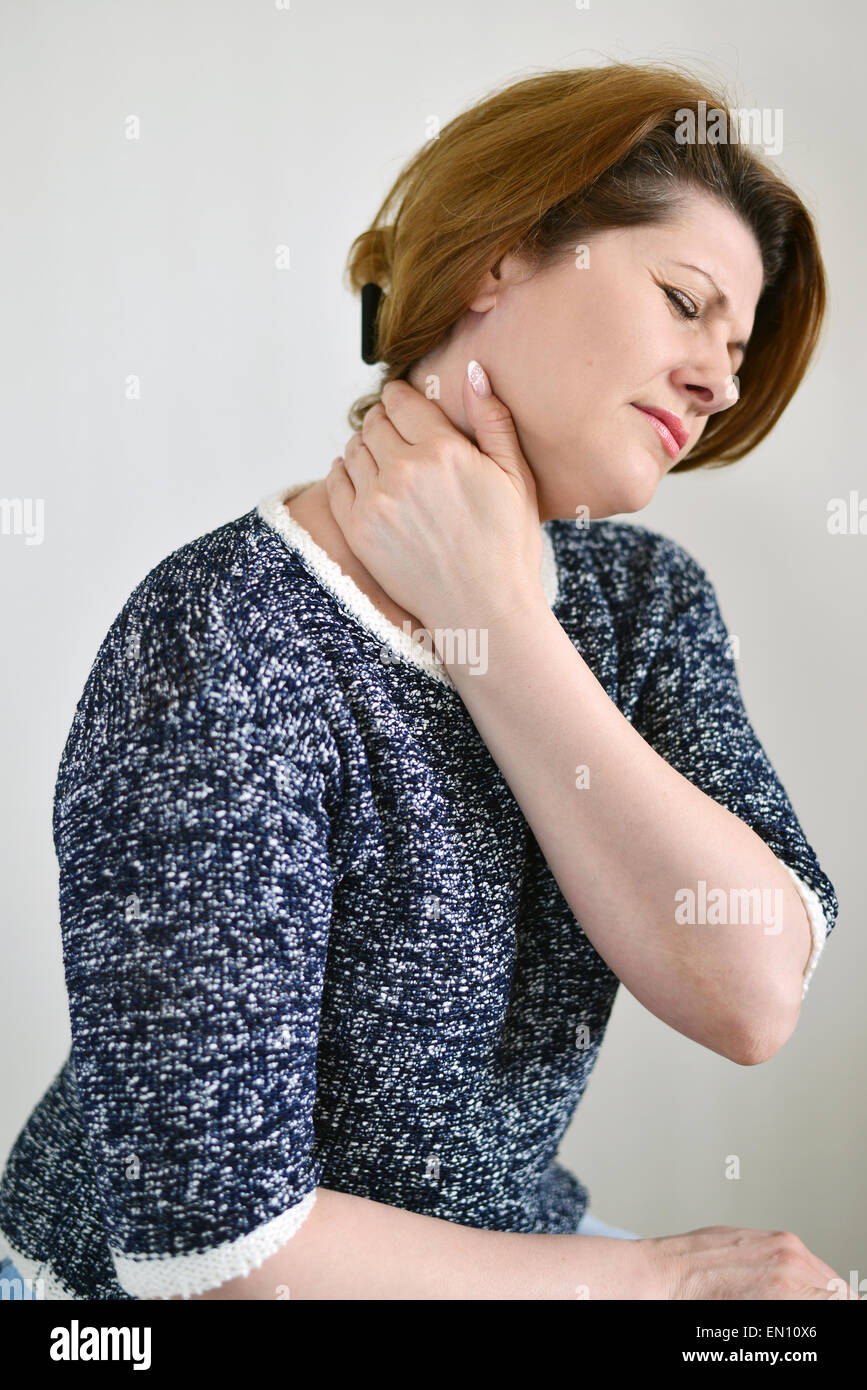 Femme adulte avec la douleur au cou sur un fond clair Banque D'Images