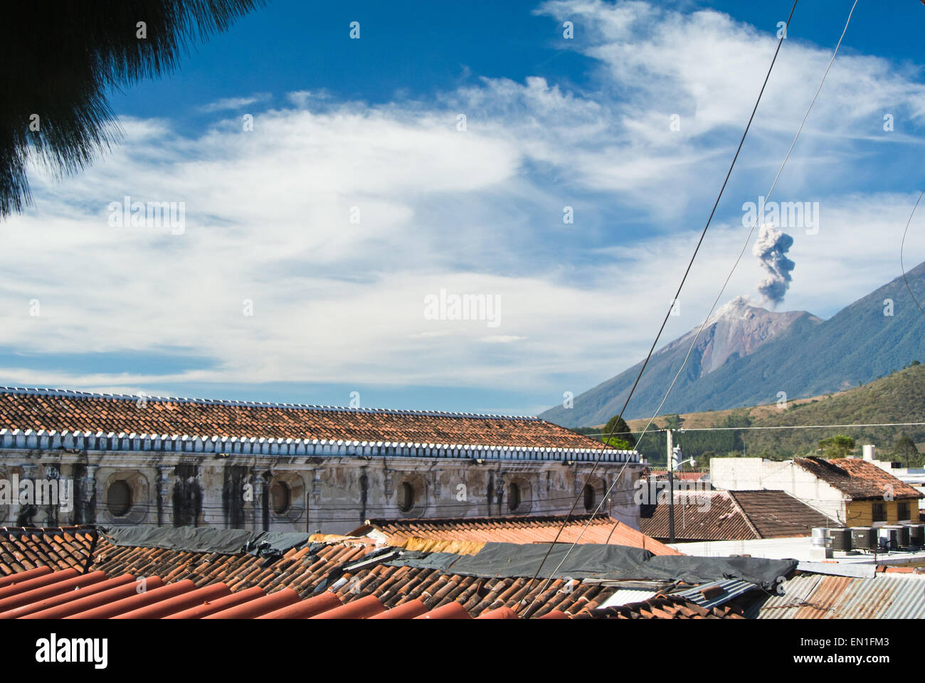 Fuego volcan actif, vu à travers des toitures de La Antigua, Guatemala Banque D'Images