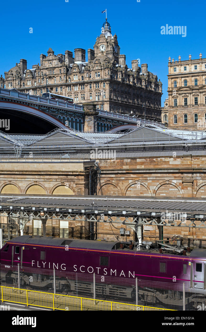 The Flying Scotsman debout à la gare de Waverley d'Édimbourg est à l'hôtel Balmoral à l'arrière-plan. Banque D'Images