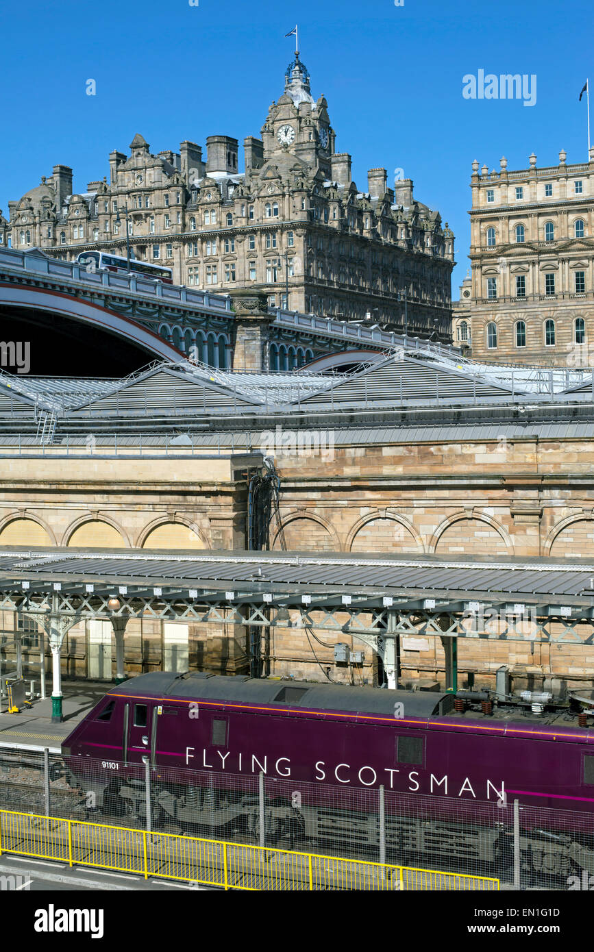 The Flying Scotsman debout à la gare de Waverley d'Édimbourg est à l'hôtel Balmoral à l'arrière-plan. Banque D'Images