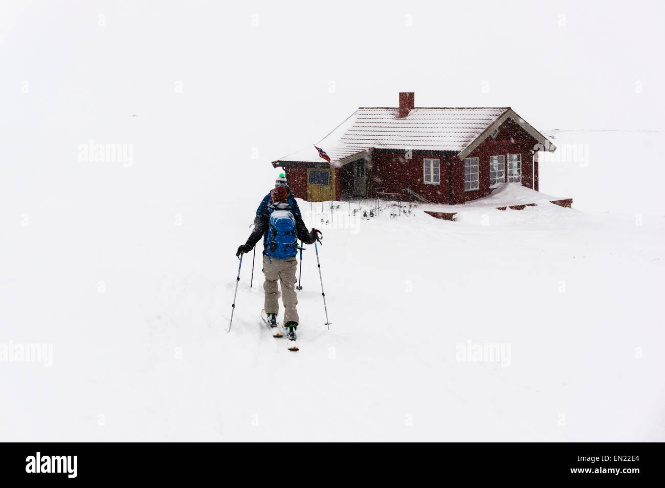 Les skieurs à l'approche d'un refuge de montagne dans des conditions de voile blanc près de Lyngseidet, Alpes de Lyngen (Troms, Lyngsalpene) de la Norvège. Banque D'Images