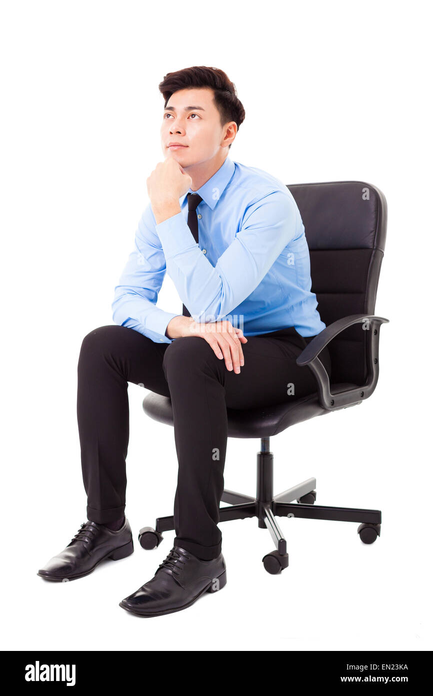 Jeune homme assis sur une chaise et la pensée Banque D'Images