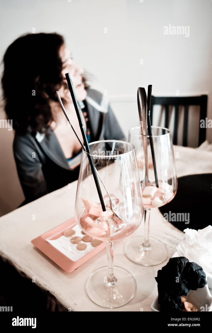 Femme au bar parler, deux verres vides de Sangria avant-plan, avec facture payée à côté, l'Espagne. Banque D'Images