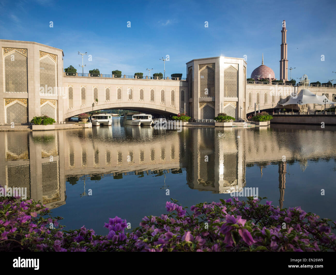 Pont et son reflet, avec des bateaux en dessous et une mosquée dans l'arrière-plan Banque D'Images