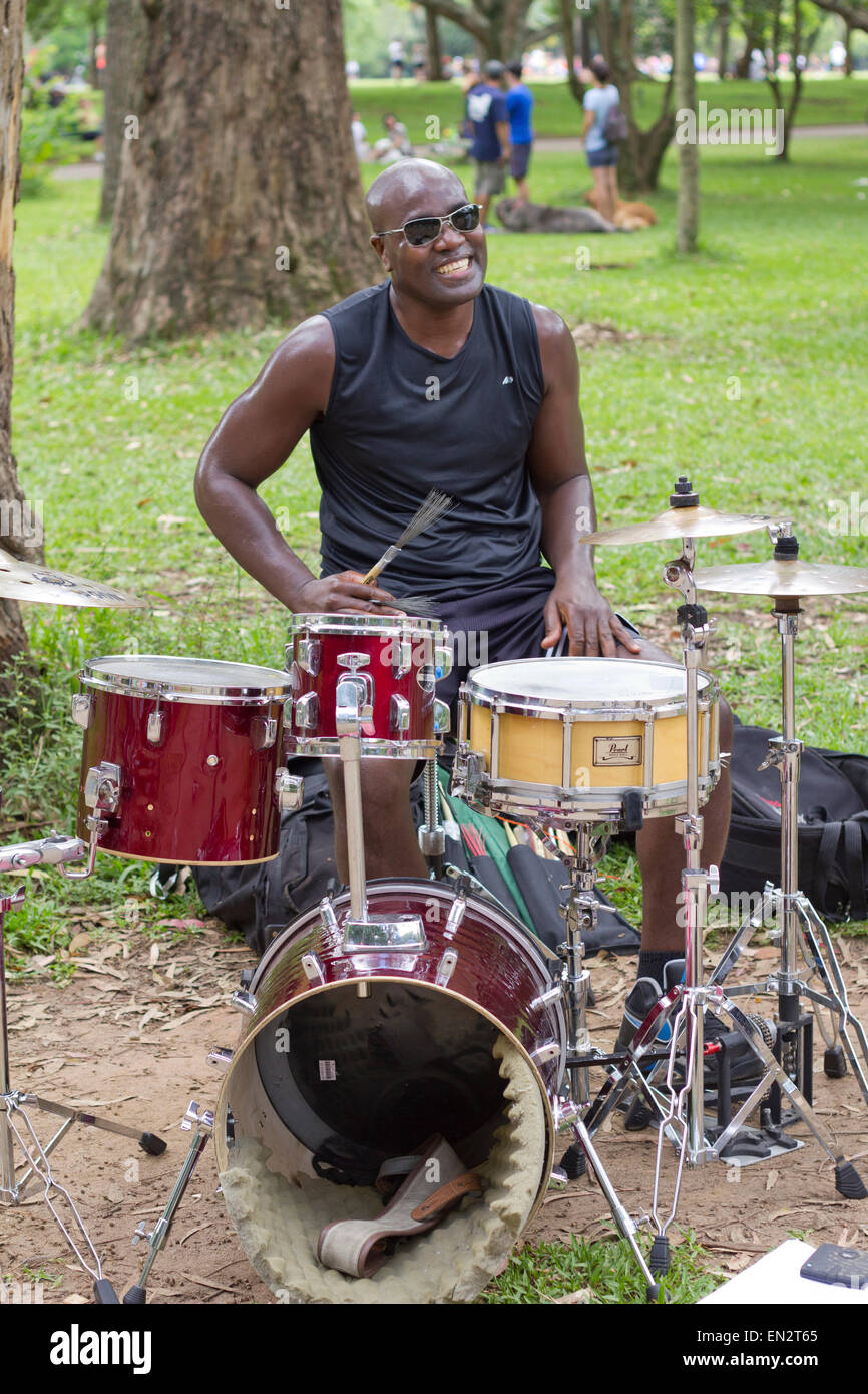 SAO PAULO, BRÉSIL - février 01, 2015 : Un musicien de rue chantant et jouant de la batterie dans le parc d'Ibirapuera à Sao P Banque D'Images