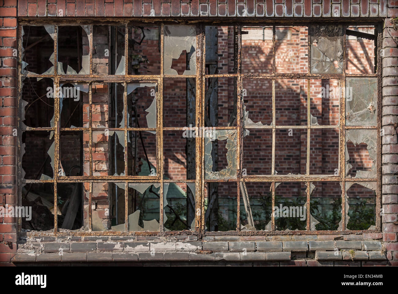 Un vieux châssis de fenêtre fer industriel la rouille avec du verre brisé. Banque D'Images