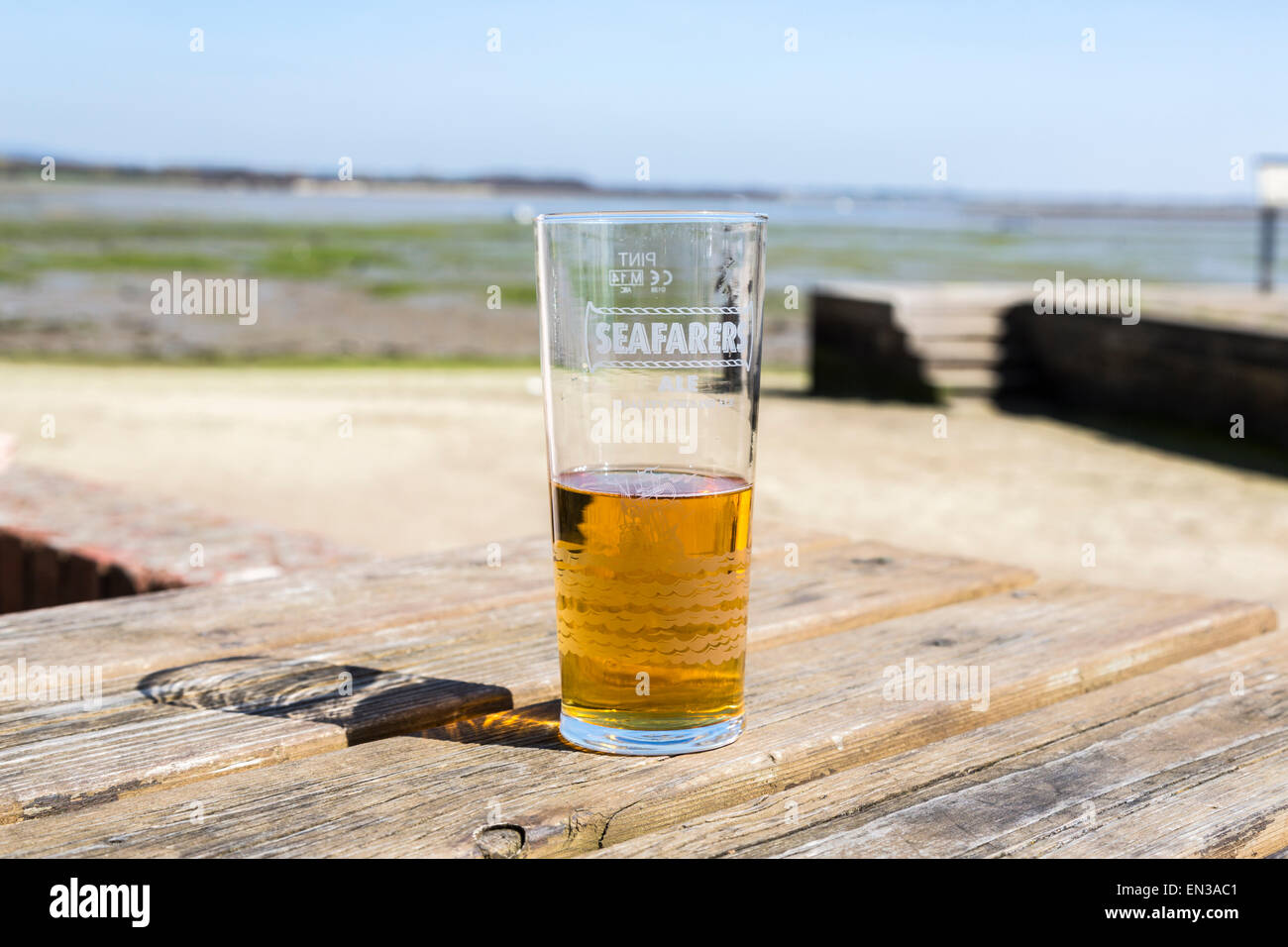 À moitié vide, ou à moitié plein, le verre de bière ou de shandy sur une table en bois, verre pub marqué pièce d'Ale Banque D'Images