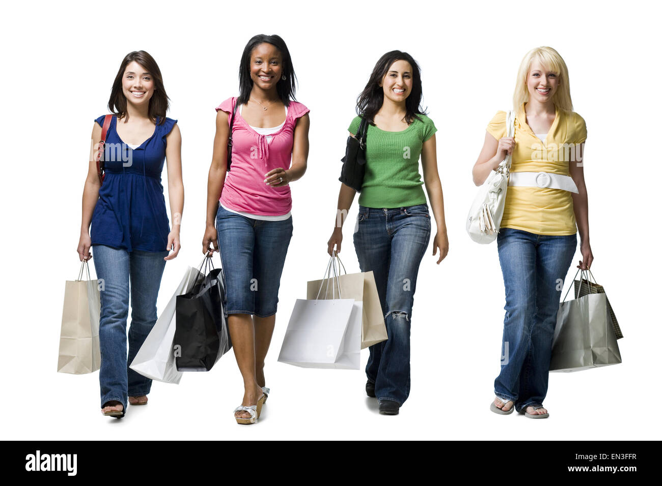 Quatre femmes randonnée smiling with shopping bags Banque D'Images