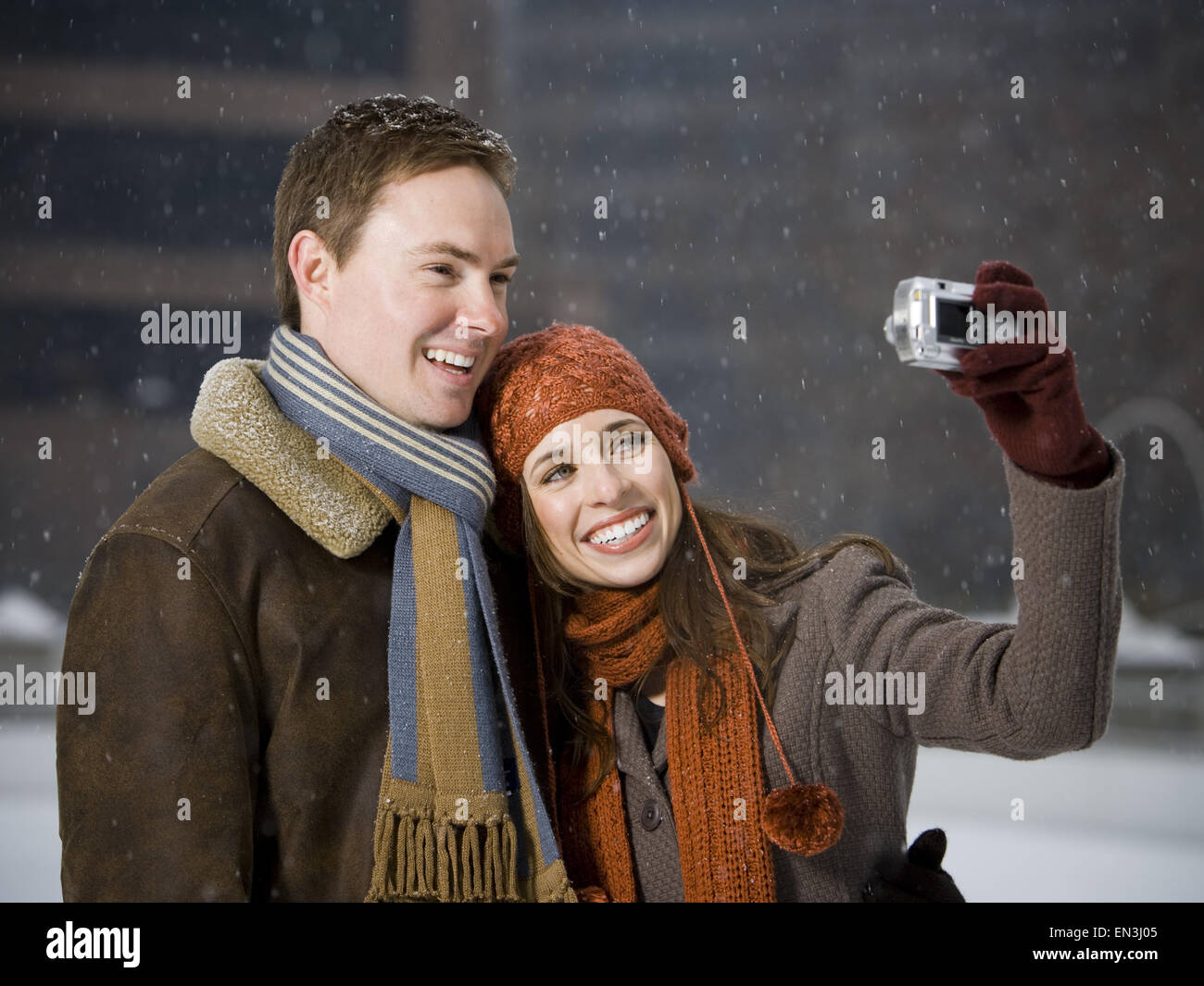 L'homme et de la femme de prendre une photo à l'extérieur en hiver Banque D'Images