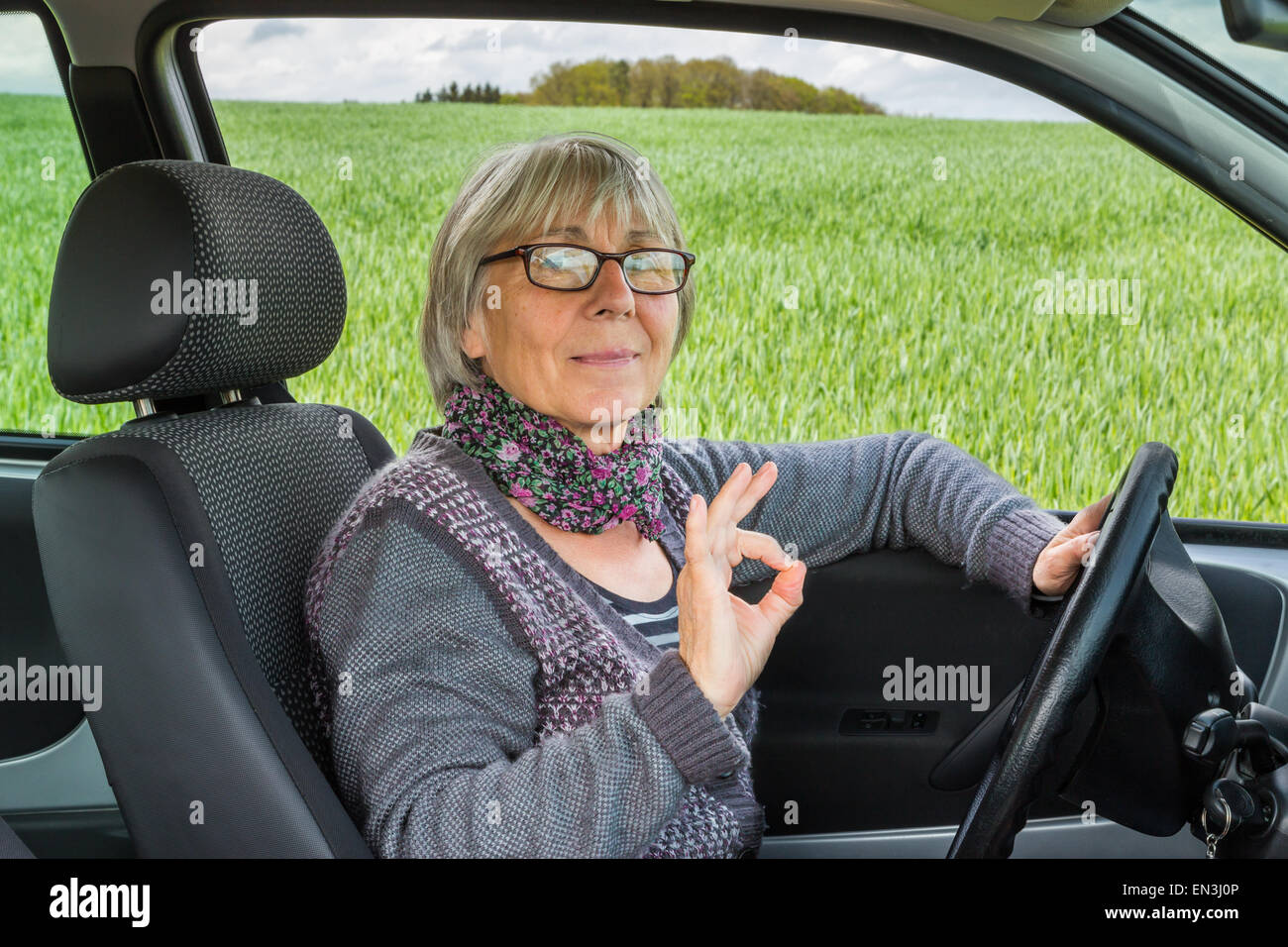 Senior Woman dans la voiture montre tout parfait. Banque D'Images