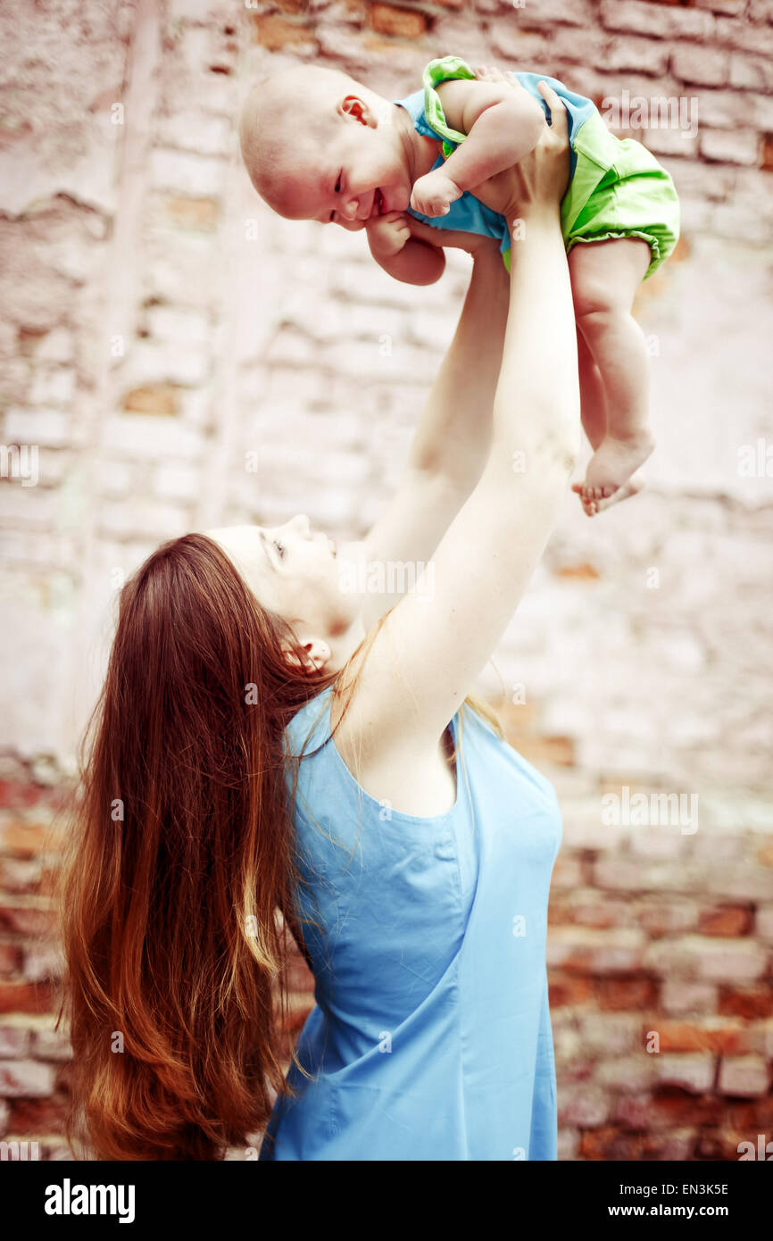 Belle jeune femme jouer avec bébé. Famille heureuse. Instagram-comme effet  vintage Photo Stock - Alamy