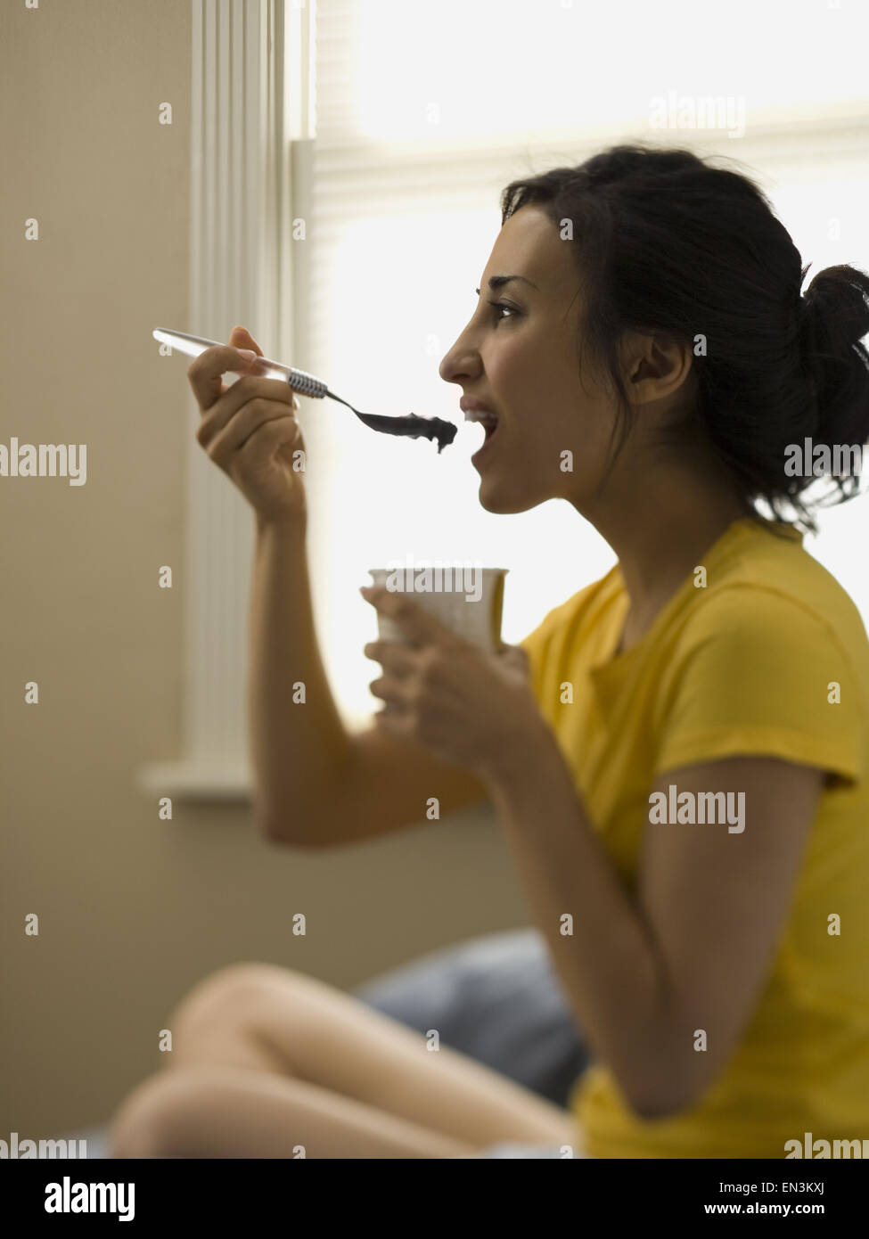 Femme assise et la consommation de crème glacée Banque D'Images