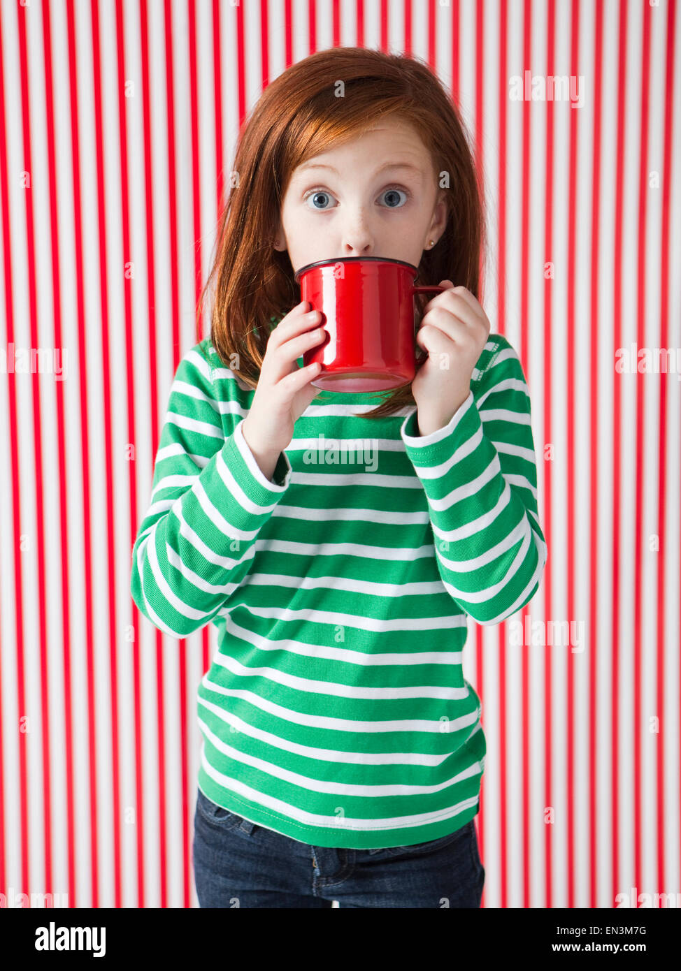 Studio Portrait of Girl (4-5) de boire une tasse rouge Banque D'Images