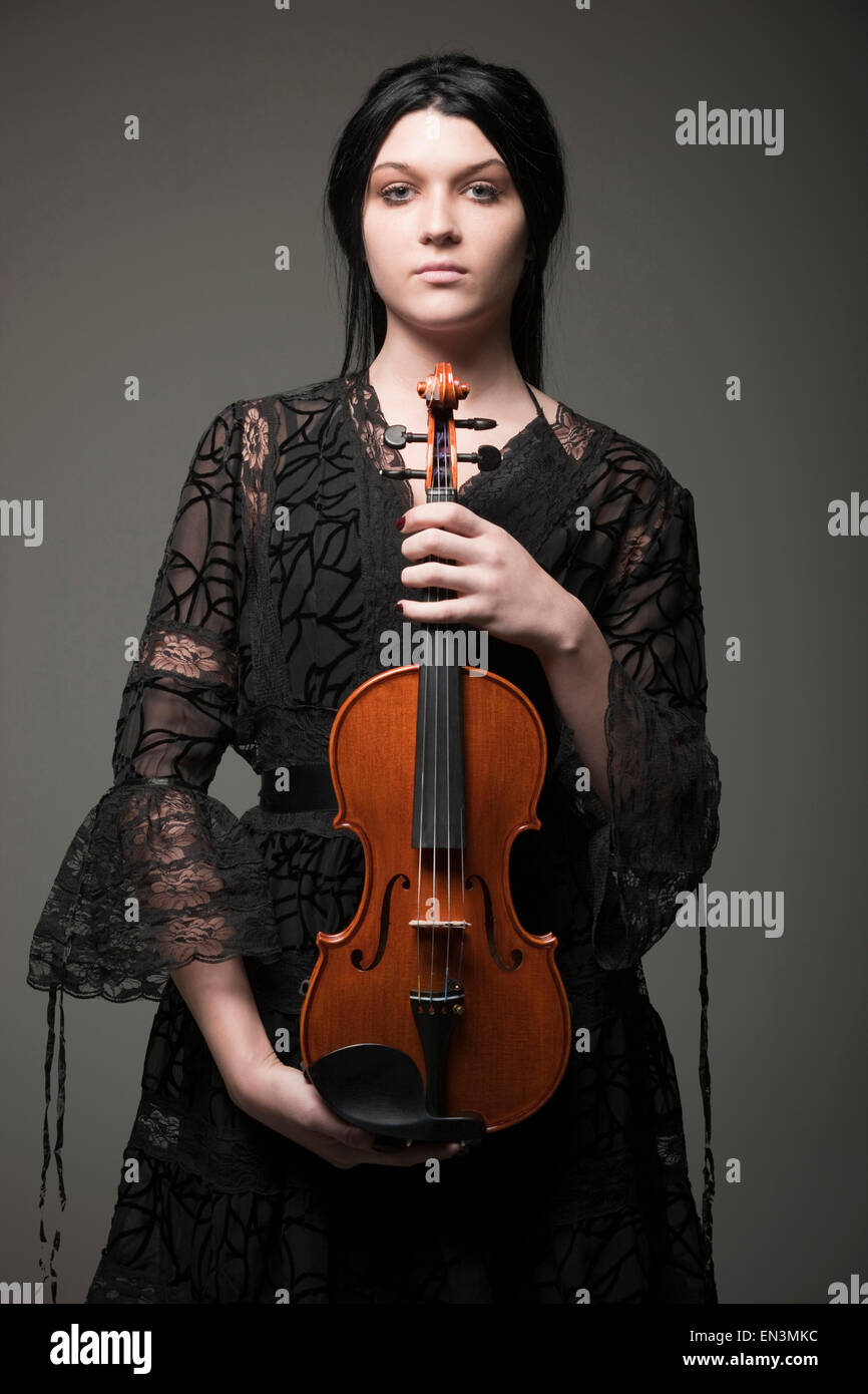 Studio portrait of young woman holding violin Banque D'Images
