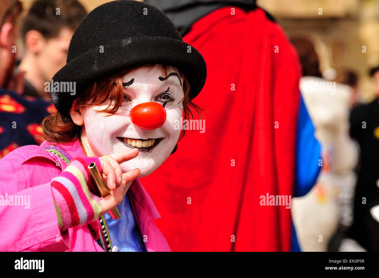 Clown avec blanc visage peint et nez rouge portant un chapeau dans le Guildhall Square, Derry, Londonderry, en Irlande du Nord. Banque D'Images
