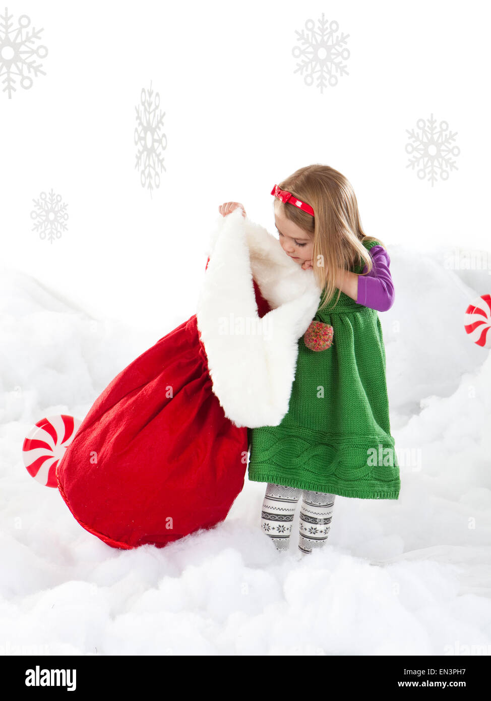 Portrait of Girl (18-23 mois) peeking à Santa bag Banque D'Images