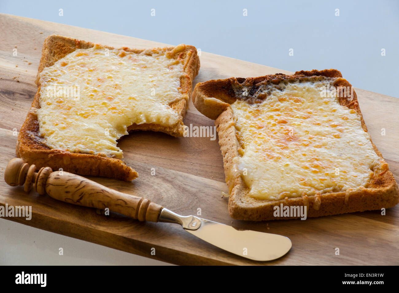 Fromage sur toast avec un morceau pris hors de lui. Banque D'Images