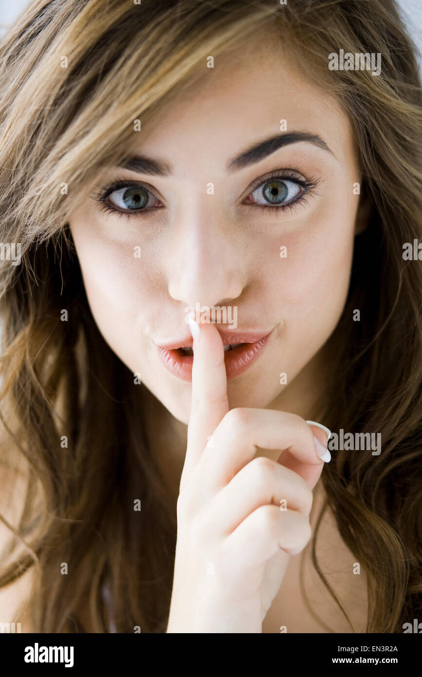 Femme avec son doigt sur ses lèvres Banque D'Images