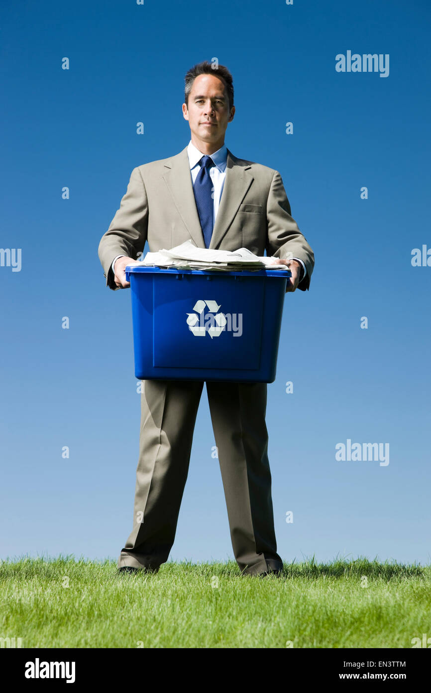 Businessman holding a recycling bin Banque D'Images