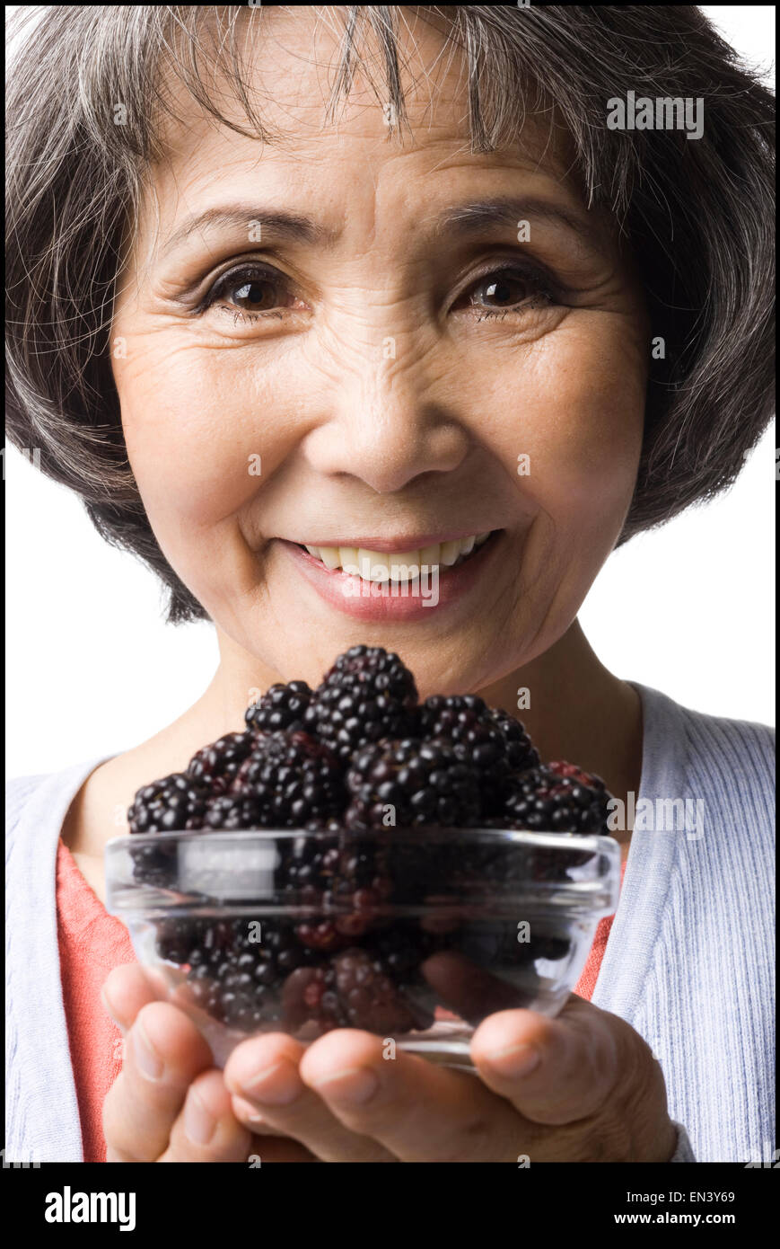 Woman holding up un bol de mûres Banque D'Images