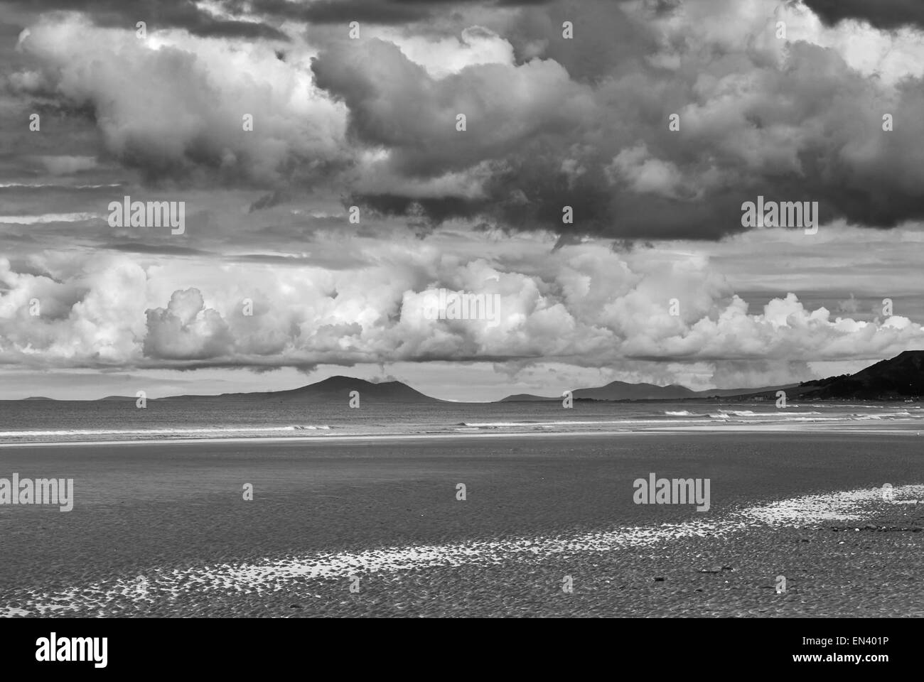 Image noir et blanc de nuages dramatiques qui pèsent sur la plage en Ynyslas, au Pays de Galles. Banque D'Images