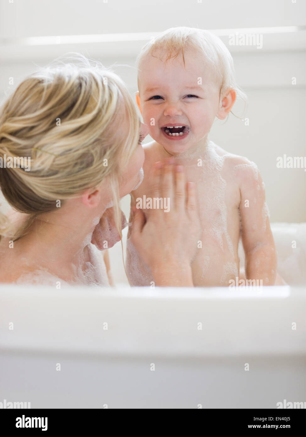 La mère et l'enfant prenant un bain moussant Banque D'Images
