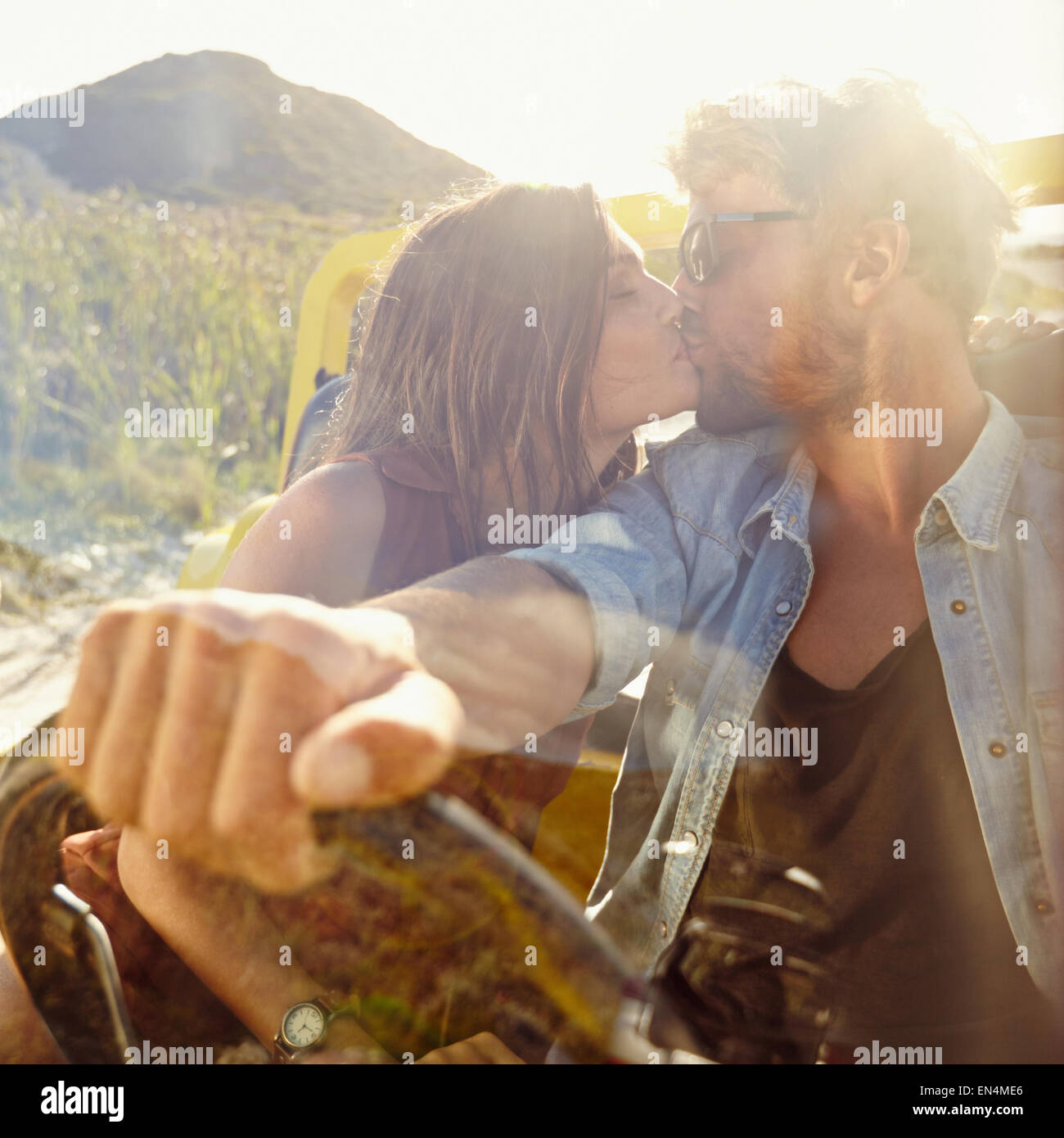 Jeune couple s'embrasser dans la voiture. Couple in love on road trip s'amusant. Banque D'Images