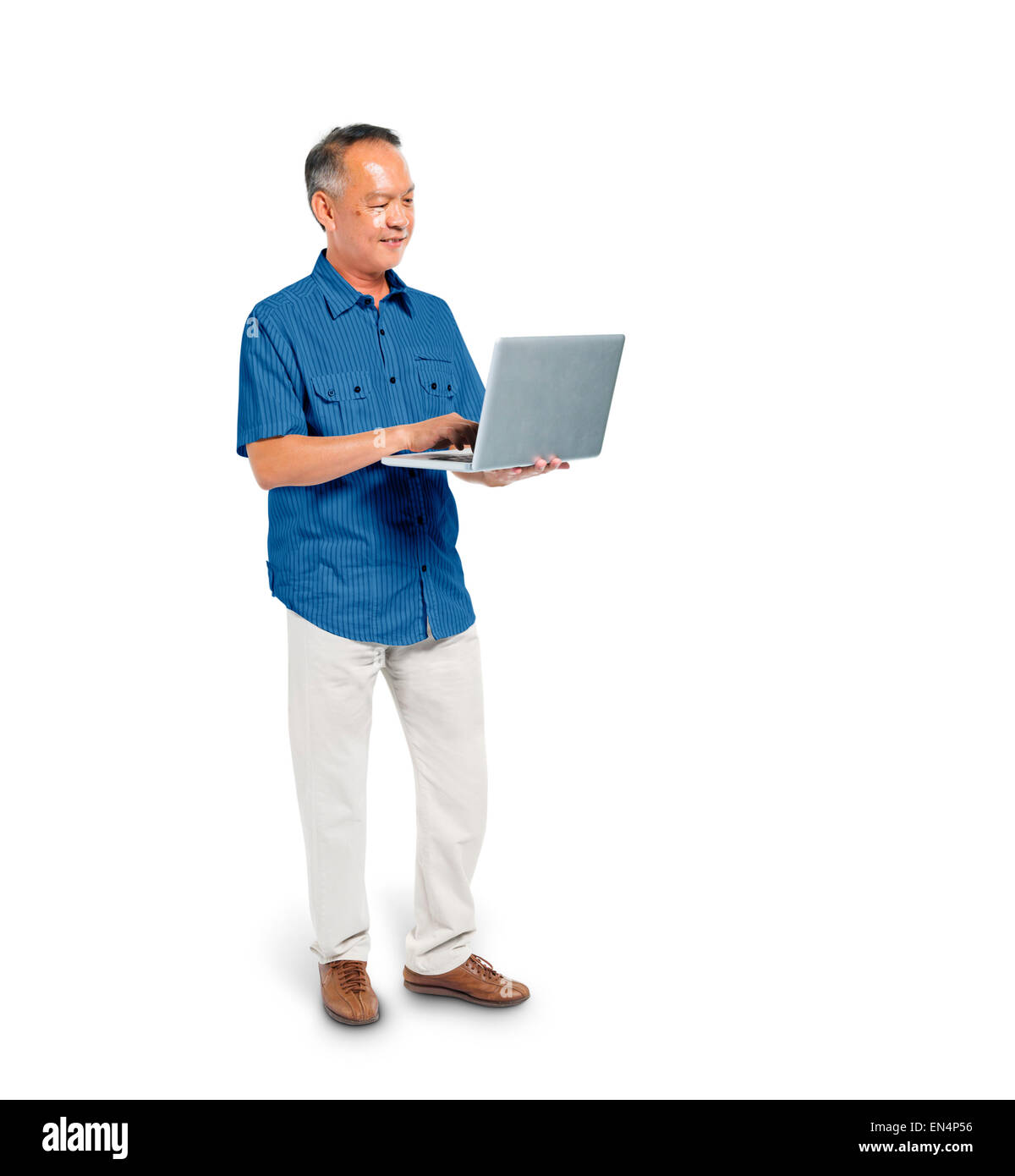 Une smart casual Man La navigation sur Internet avec son ordinateur portable Banque D'Images