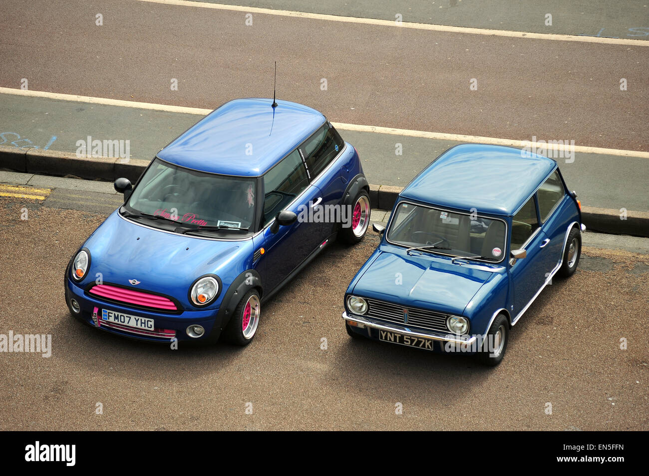 Un original mini bleue garée à côté d'un mini moderne sur Madeira Drive à Brighton. Banque D'Images