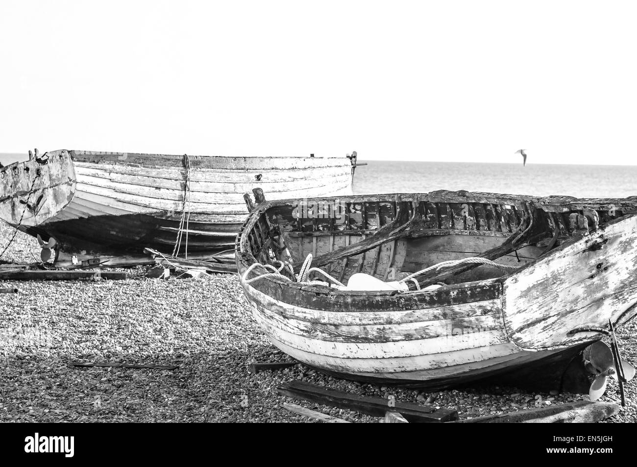 Ton pâle bateaux de pêche sur une plage de galets (gravier) à la mer. B&W Banque D'Images