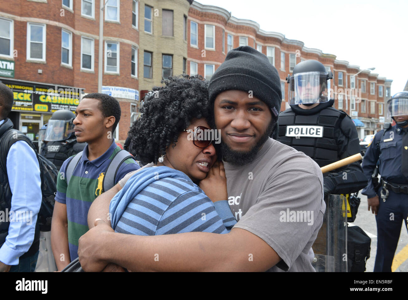 Baltimore, MD, Baltimore, Maryland, USA. Apr 28, 2015. Deux résidents embrasser dans une intersection de Baltimore qui avait été le site de pillage la nuit précédente. Au cours d'une nuit d'indignation suscité par la mort de 25 ans gris de Freddie en garde à vue, la ville a vu plus d'une douzaine d'incendies de bâtiments, près de 200 arrestations, et 19 policiers blessés. Crédit : Jay Egelsbach/ZUMA/Alamy Fil Live News Banque D'Images