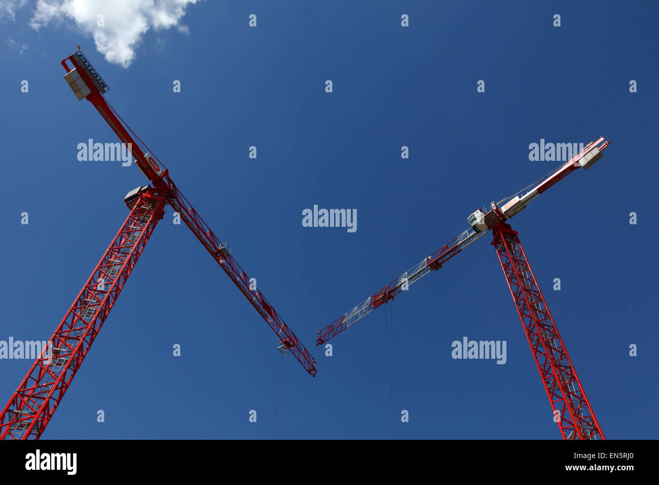 Les grues rouges contre un ciel bleu sur un site de construction Banque D'Images