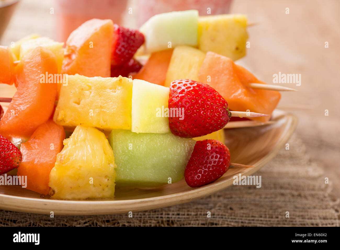 Brochettes de fruits - fruits en brochettes - sur plateau avec smoothies fraises Banque D'Images