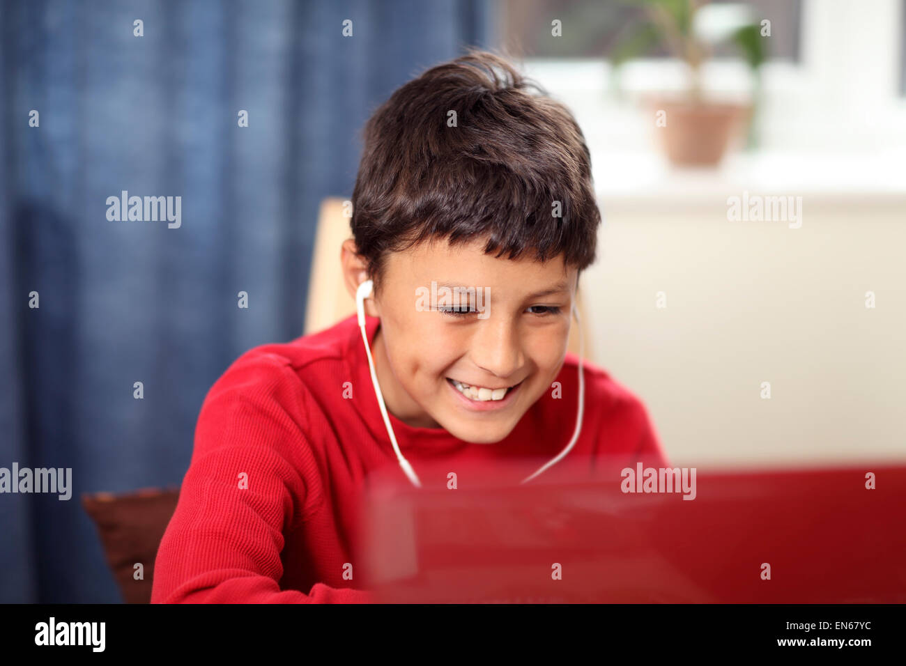 Jeune garçon fait ses devoirs sur un ordinateur - avec une faible profondeur de champ Banque D'Images