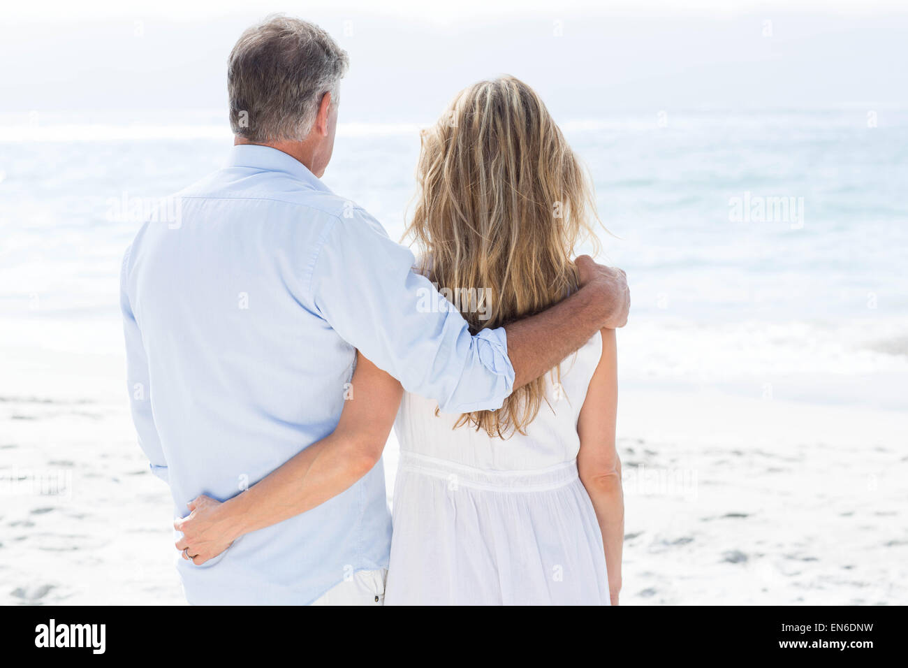 Heureux couple debout près de la mer autour d'armes Banque D'Images