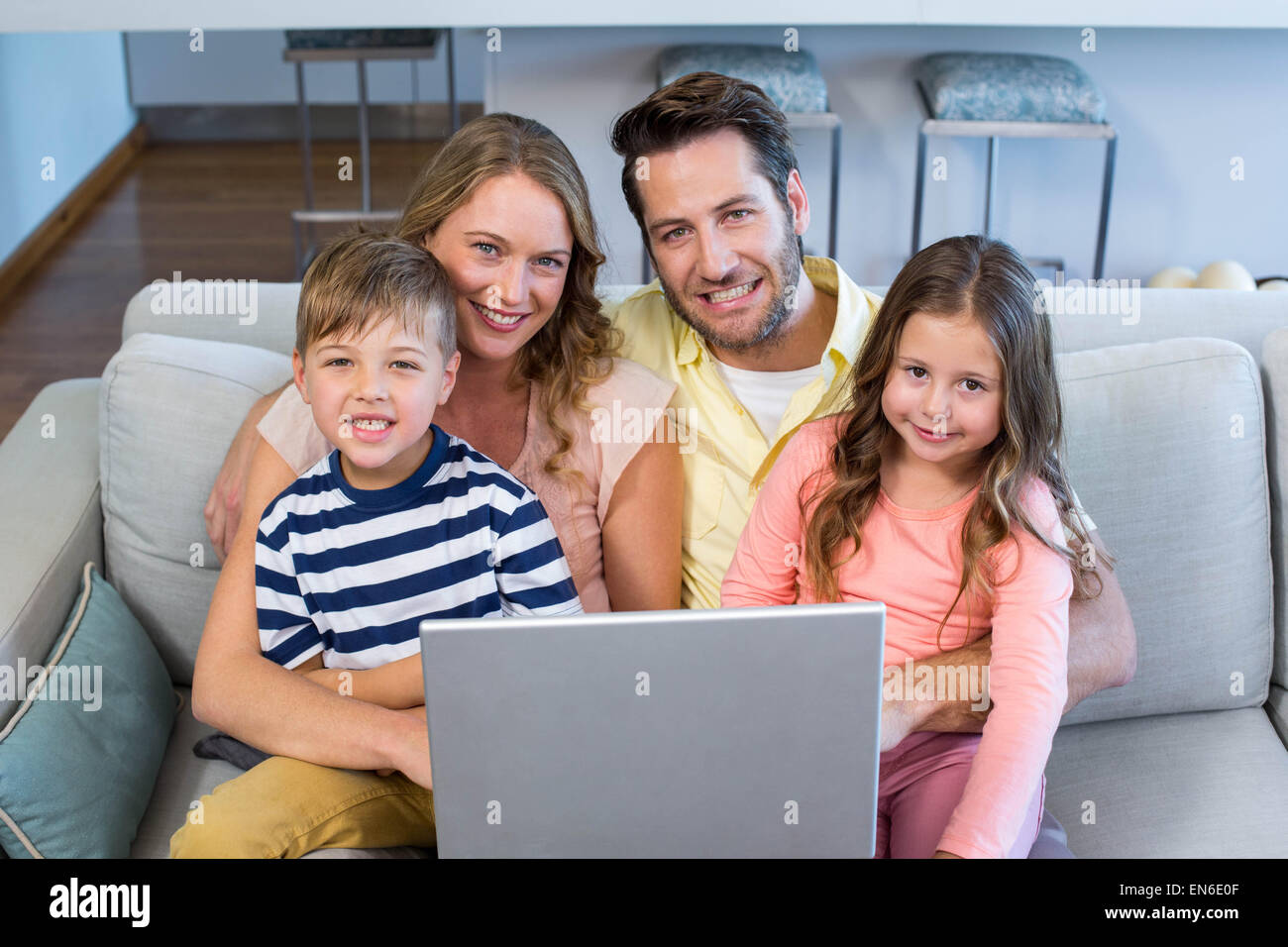 Famille heureuse en utilisant l'ordinateur portable ensemble Banque D'Images