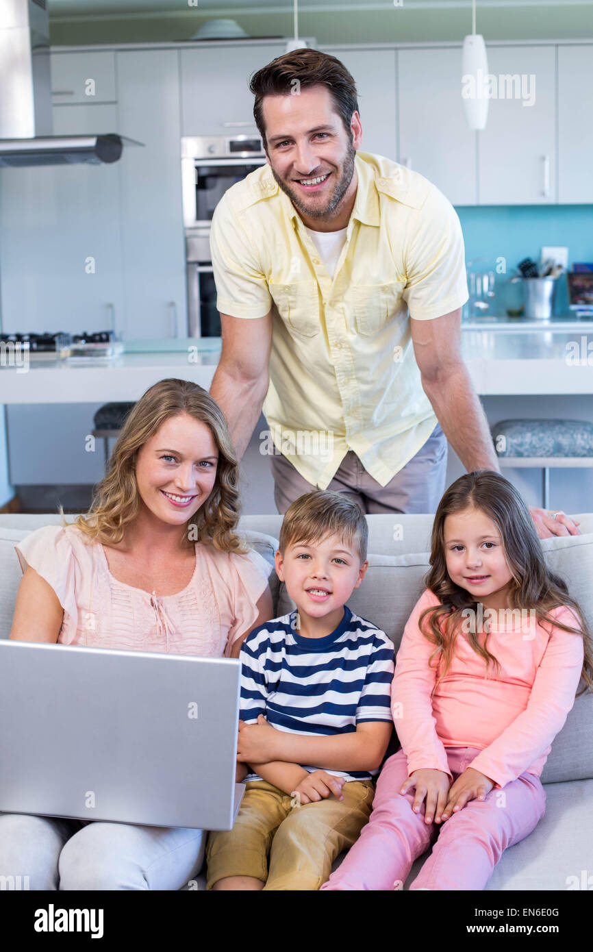 Famille heureuse sur le canapé à l'aide d'ordinateur portable Banque D'Images