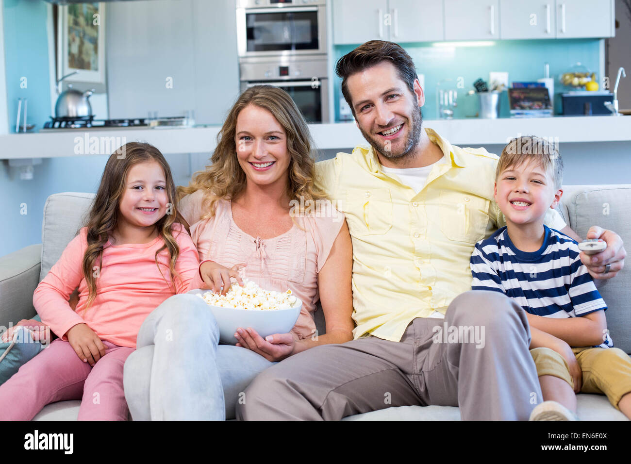 Famille heureuse sur le canapé en regardant la télé Banque D'Images