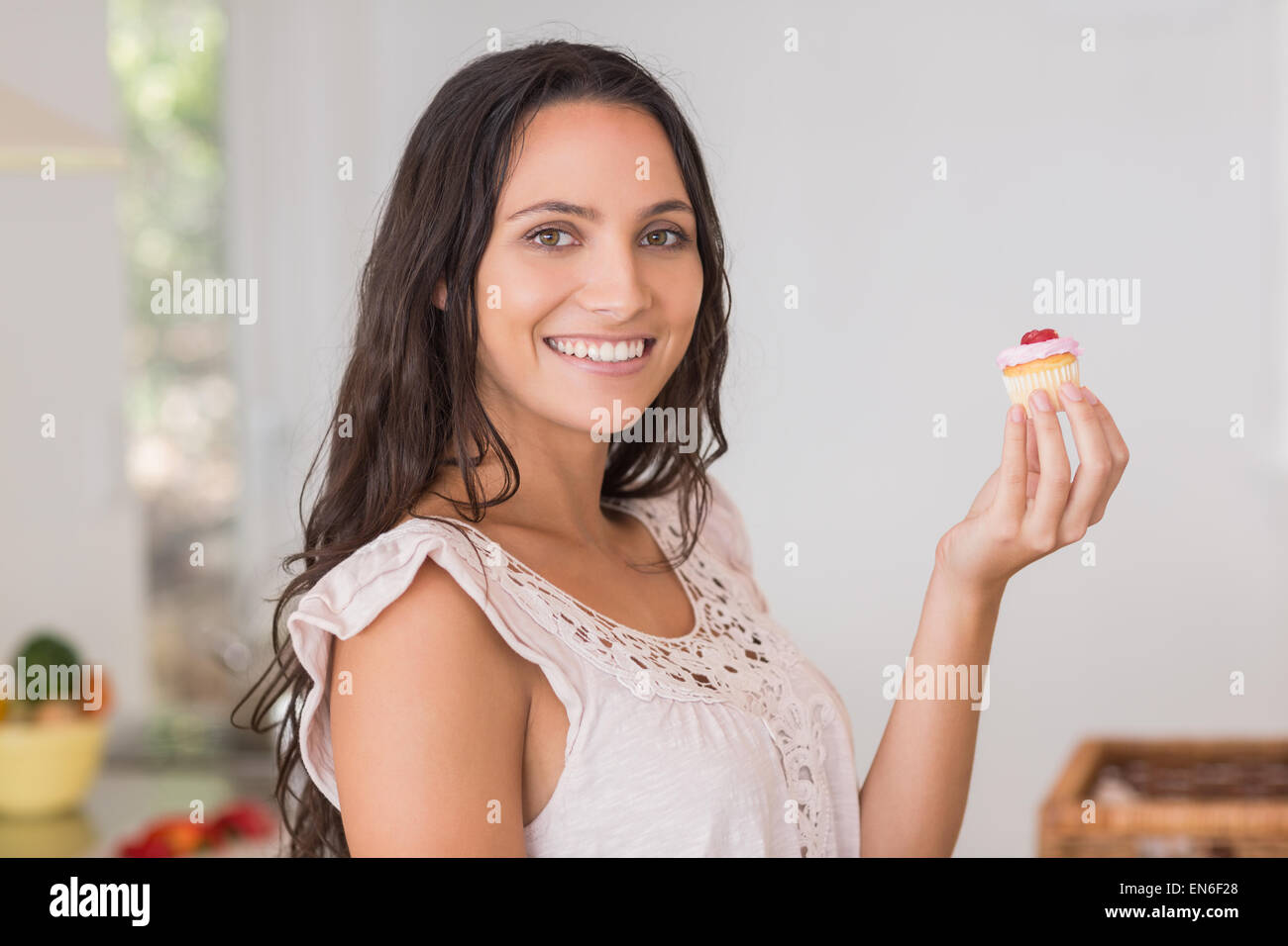 Belle brunette holding mini cupcake Banque D'Images