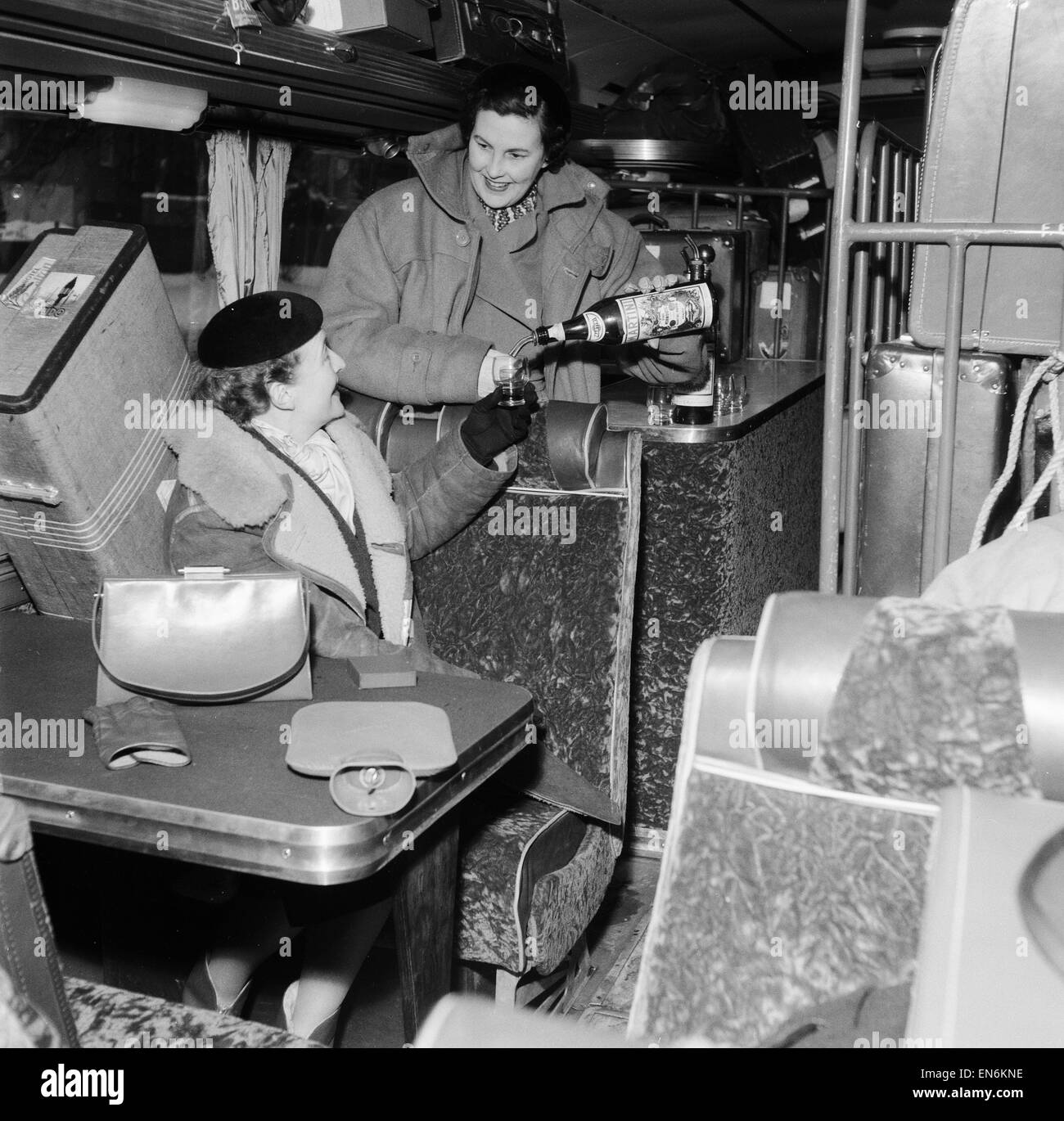 Monte Carlo or Bust. Quitter cette semaine à un coach de prendre les bagages des pilotes de Monte Carlo sont deux de leurs femmes, Mme Nevil Lloyd (l) et Mme Jack Kemsley (r), l'entraîneur est également équipé d'un bar à cocktails, dimanche 16 janvier 1955. Banque D'Images